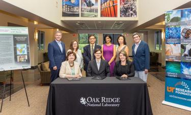 Seated are Michelle Buchanan, ORNL deputy for science and technology; Alex Lewis, CEO of Electro-Active Technologies; and Stacey Patterson, University of Tennessee Research Foundation president, who signed the licensing agreement for two ORNL microbial electrolysis technologies. Standing, from left, are Mike Paulus and Jennifer Caldwell of ORNL; Abhijeet Borole of Electro-Active Technologies; Maha Krishnamurthy of UTRF; and Edna Gergel and Brian Davison of ORNL. Credit: Carlos Jones/Oak Ridge National Labor