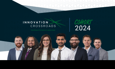 Group photo of the Innovation Crossroads Cohort 2024 at Oak Ridge National Laboratory. The image features seven individuals standing side by side, all dressed in professional attire. The background includes the Innovation Crossroads logo and the text 'Cohort 2024'