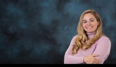 Young women in a pink sweater in front of a traditional blue background
