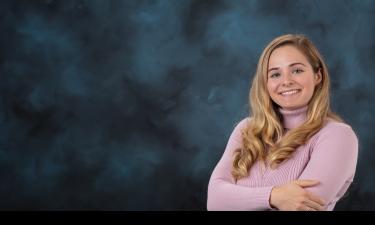 Young women in a pink sweater in front of a traditional blue background 