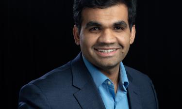 Professional portrait of man in suit in front of a solid black background