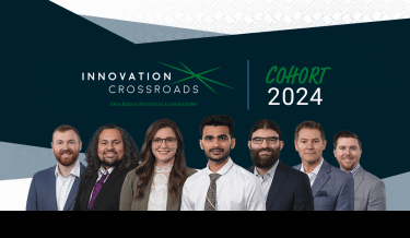 Group photo of the Innovation Crossroads Cohort 2024 at Oak Ridge National Laboratory. The image features seven individuals standing side by side, all dressed in professional attire. The background includes the Innovation Crossroads logo and the text 'Cohort 2024'
