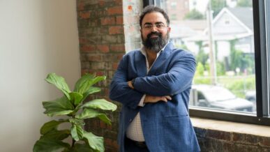 Hicham Ghossein stands with his arms crossed beside a window at his Knoxville office.